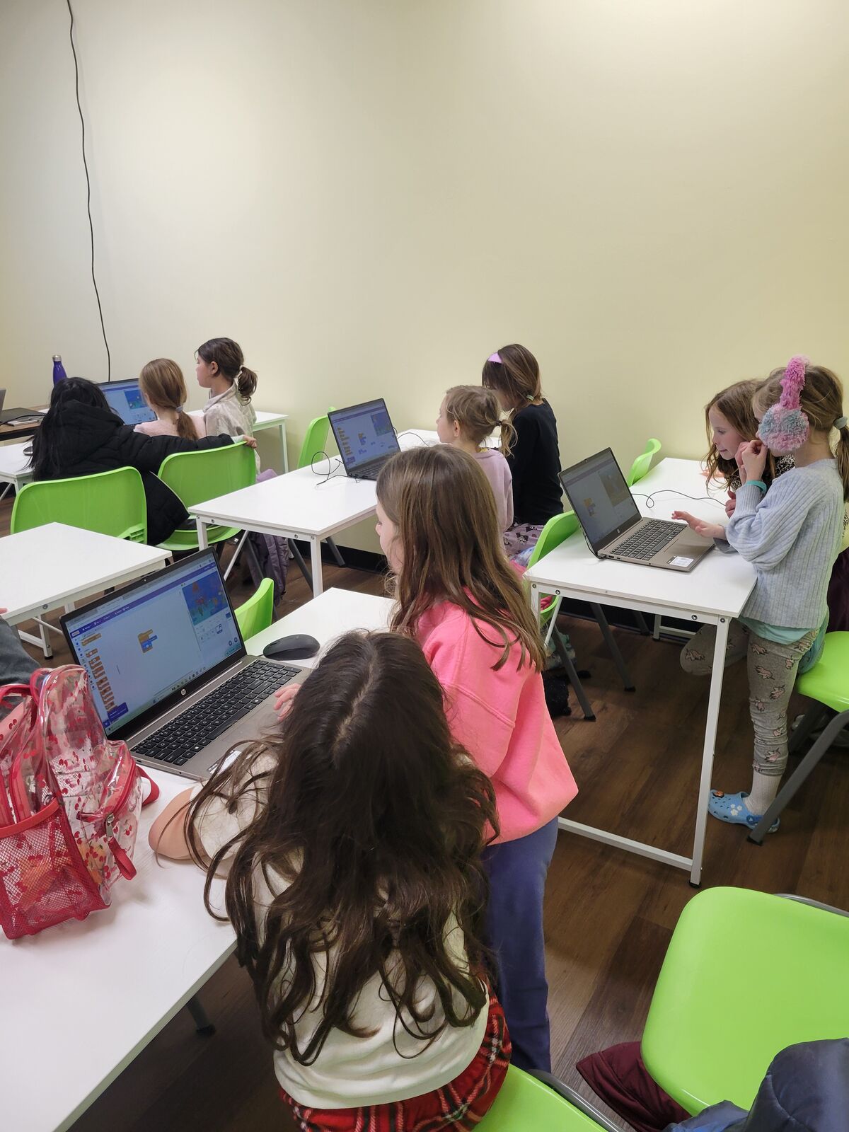 Students working on block-coding projects at classroom laptops