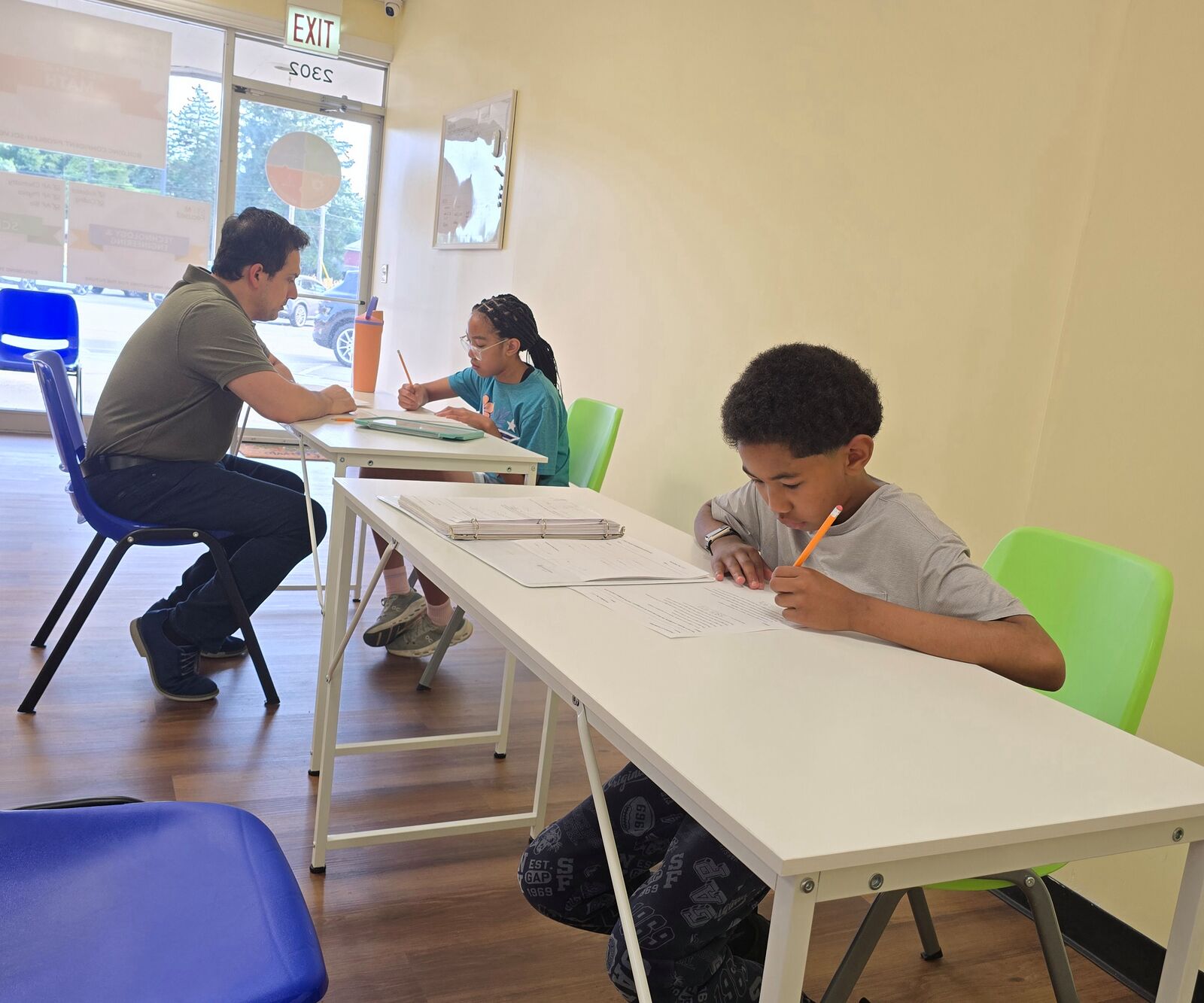 Students working through math worksheets with a tutor