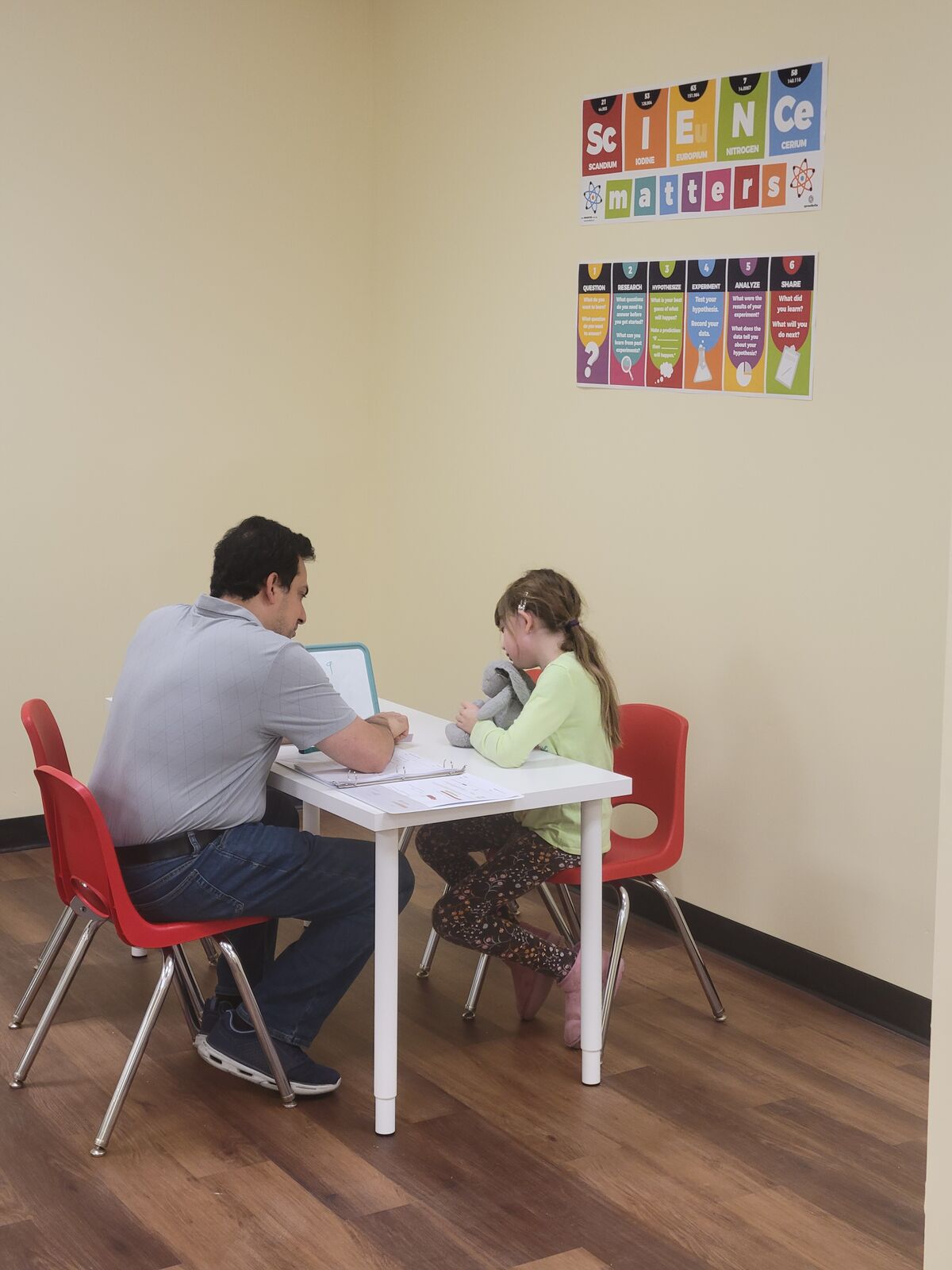 A tutor and student working through math at a small whiteboard